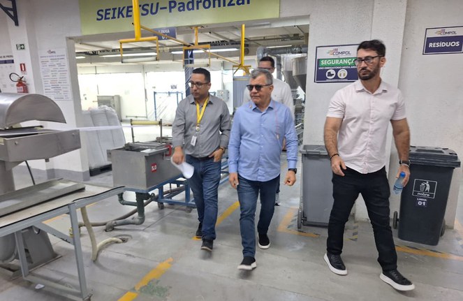 Foto mostra homens visitando uma empresa de produtos plásticos