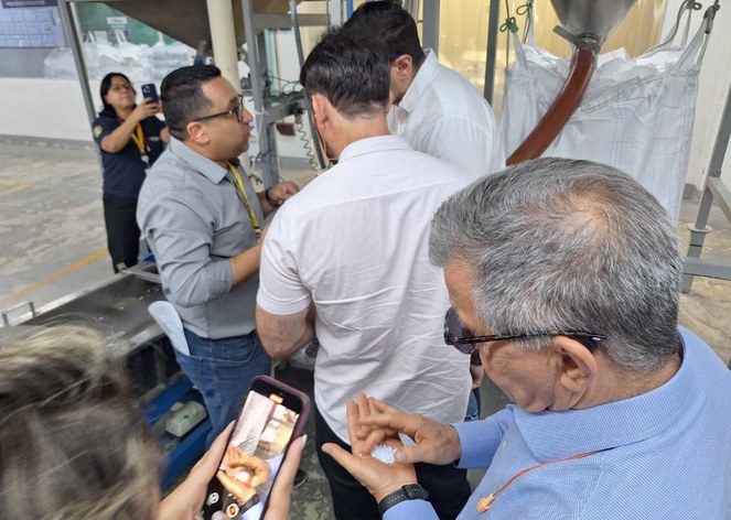 Foto mostra homem olhando para resíduos plásticos