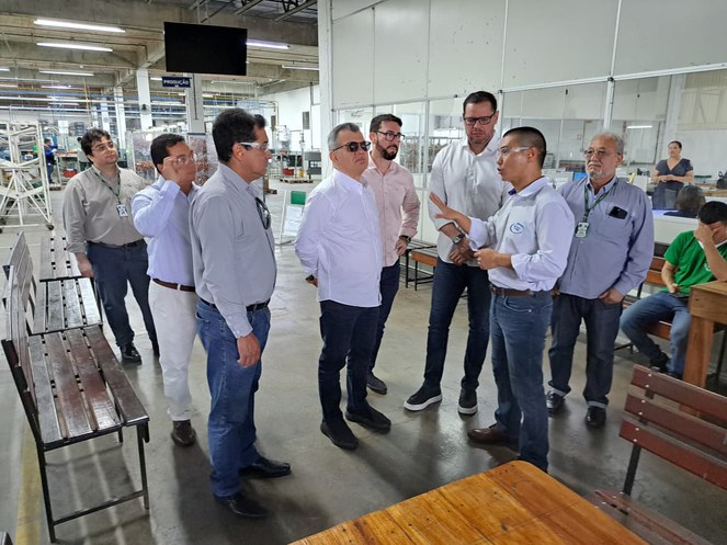 Foto mostra pessoas conversando dentro de uma empresa