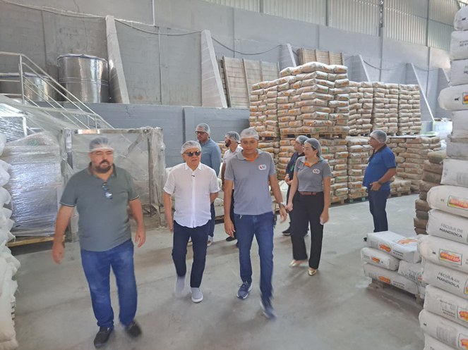 Foto mostra homens de touca cercados de saco cheios