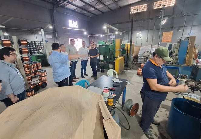 Foto mostra pessoas dentro de uma fábrica