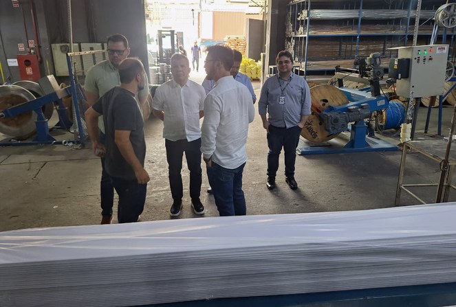 Foto mostra homens conversando em frente a forros de pvc