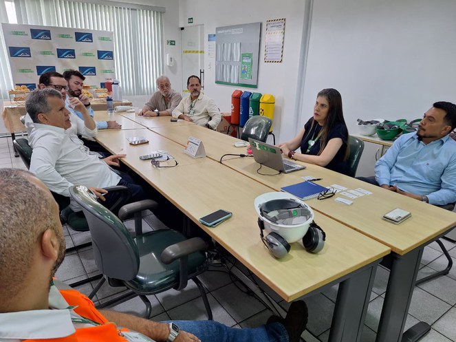 Foto mostra pessoas sentadas em uma reunião