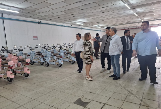 Foto mostra pessoas olhando para motocicletas