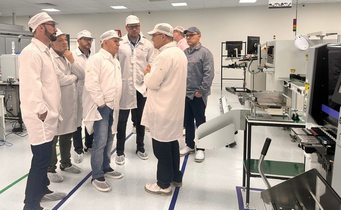 Foto mostra grupo de pessoas com jaleco e touca