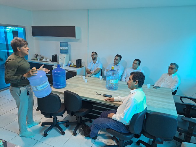 Foto mostra homem mostrando garrafão de água mineral