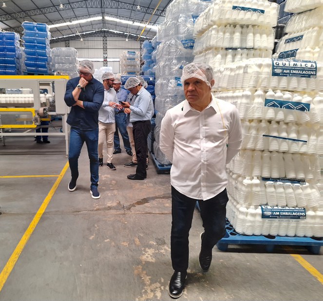 Foto mostra senhor com touca em visita a uma empresa de componentes químicos e embalagens