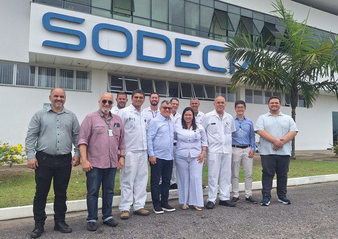 Foto mostra 11 homens e uma mulher vestida de branco posando para foto, após visita técnica a uma empresa