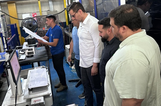 Foto mostra pessoas olhando para peças de equipamentos eletroeletrônicos