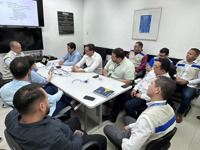Foto mostra pessoas sentadas numa reunião