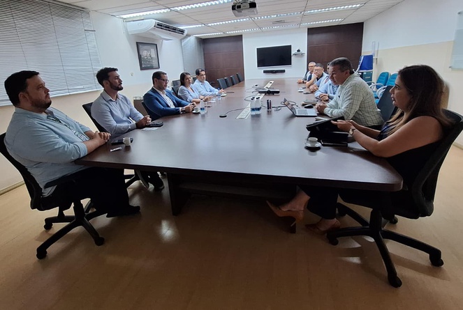 Foto mostra pessoas em uma reunião