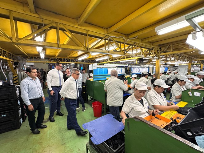 Foto mostra grupo de pessoas durante visita a uma fábrica