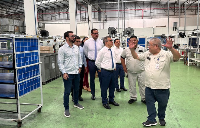 Foto mostra homem de óculos fazendo gestos a um grupo de pessoas