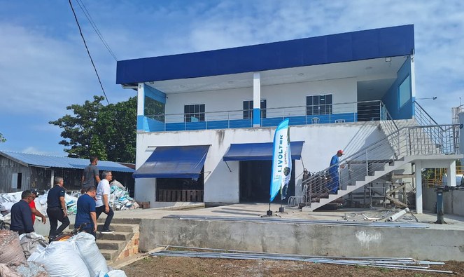 Foto mostra pessoas chegando a uma fábrica