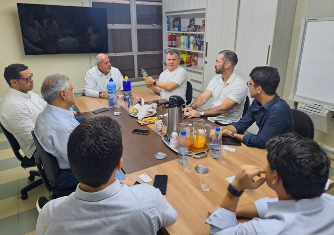 Foto mostra o superintendente da Suframa segurando um produto fabricado na empresa Topázio, durante reunião na empresain