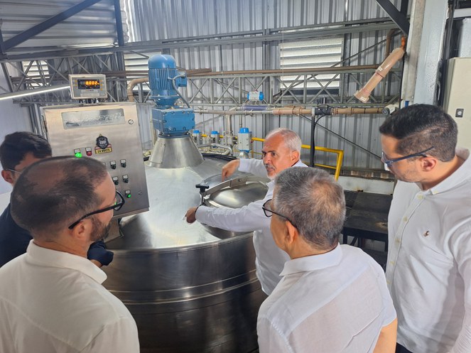 Foto mostra o diretor da empresa Topázio mostrando a linha de produção à equipe da Suframa