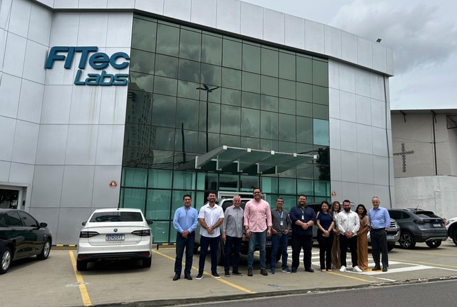 Foto mostra pessoas posando para foto em frente a um prédio