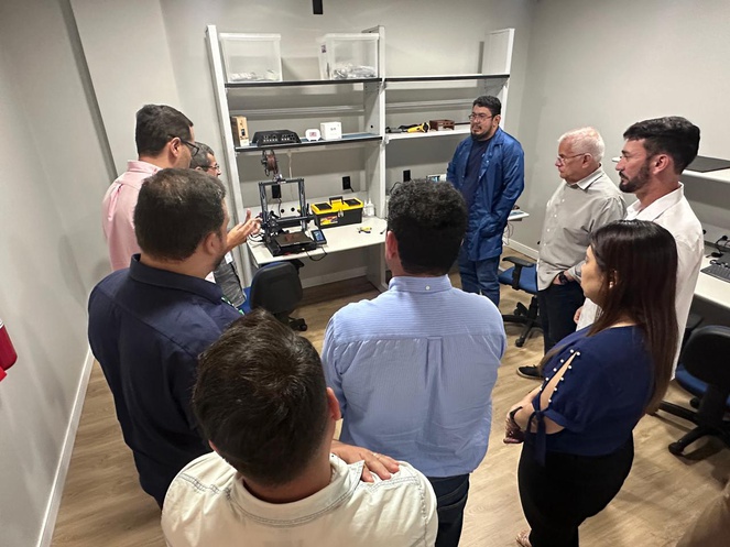 Foto mostra pessoas olhando para uns equipamentos