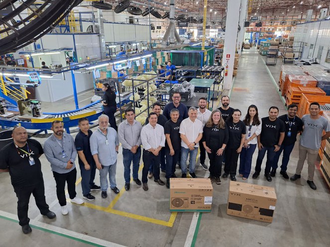 Foto mostra grupo de pessoas em visita a fábrica