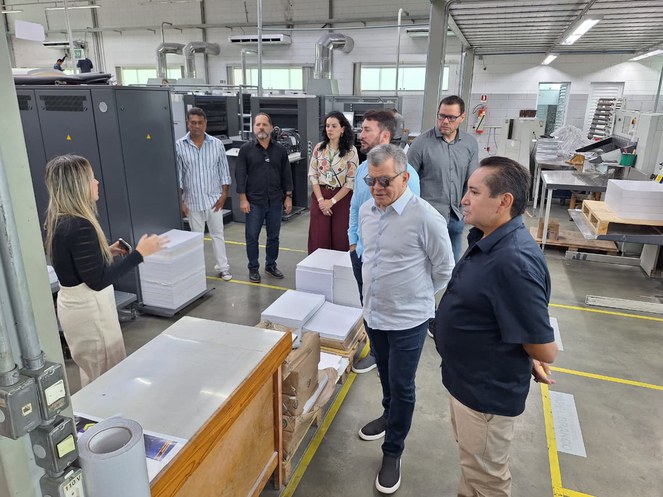 Foto mostra mulher de blusa preta fazendo uma explanação