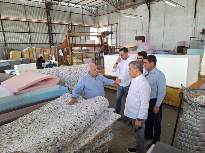 Foto mostra homens olhando para colchões