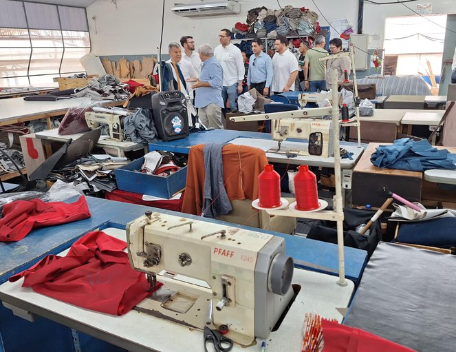 Foto pessoas em meio a máquinas de costura
