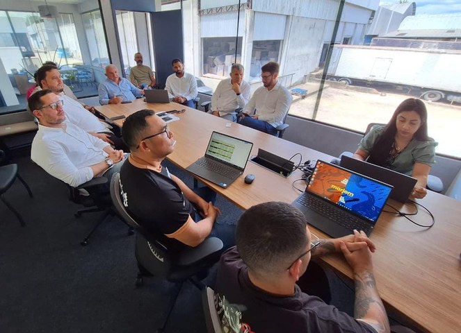 Foto mostra pessoas em uma mesa durante reunião
