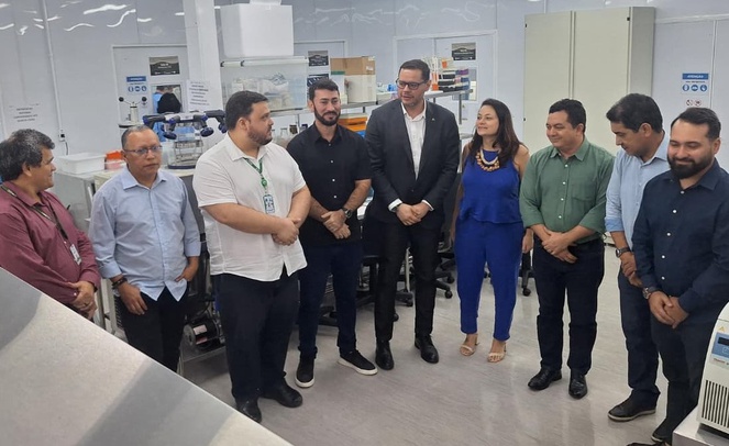 Foto mostra pessoas conversando numa sala com vários equipamentos