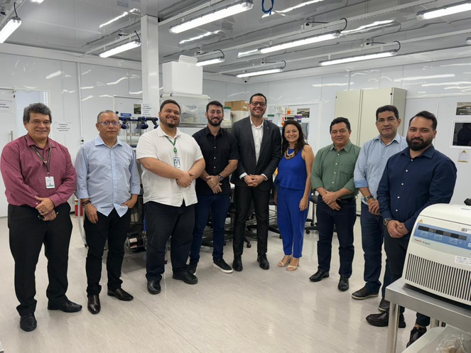 Foto mostra pessoas posando para foto numa sala com vários equipamentos