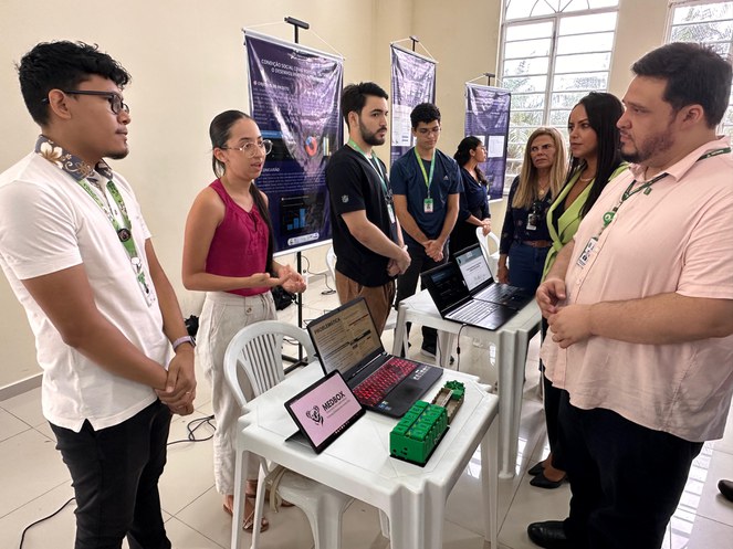 Foto mostra um grupo de pessoas numa sala
