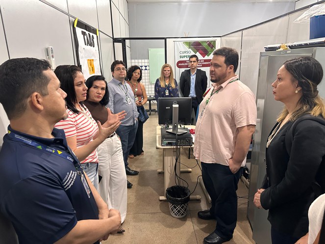 Foto mostra grupo de pessoas dentro de uma sala