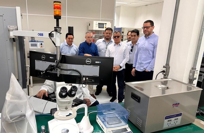 Foto mostra homens olhando para uma máquina