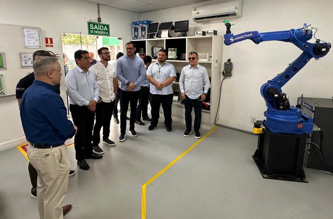 Foto mostra grupo de homens olhando para uma máquina