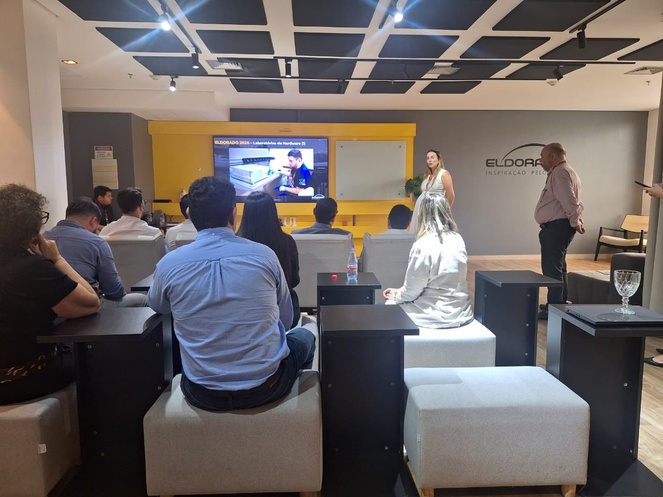 Foto mostra mulher falando a grupo de pessoas