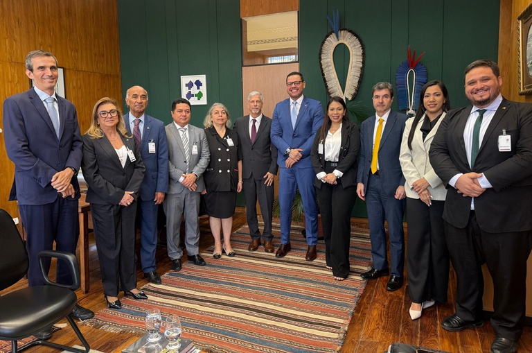 Foto mostra pessoas posando para foto numa sala