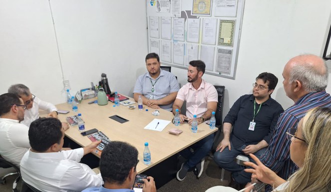 Foto mostra grupo de pessoas em reunião numa sala