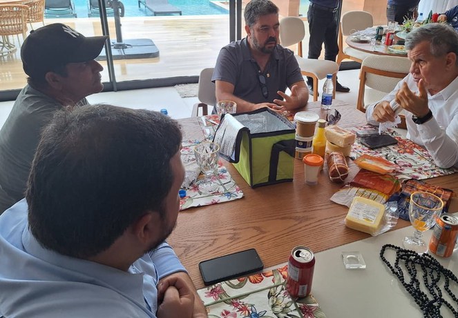 Foto mostra pessoas sentadas à mesa composta por produtos de laticínios