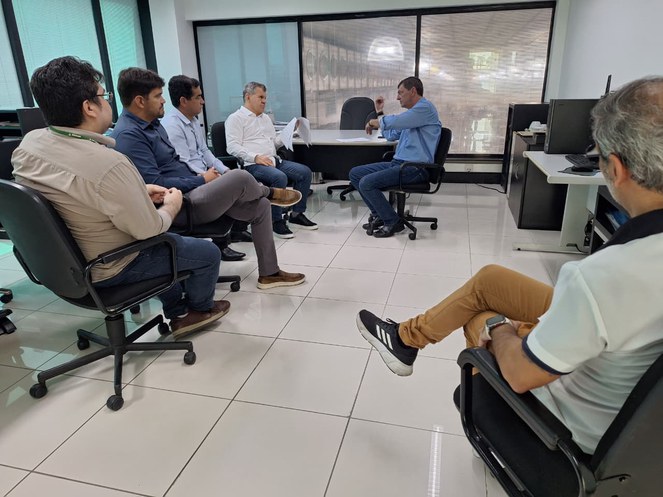 Foto mostra homens numa sala em reunião