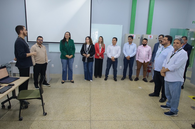 Foto mostra rapaz de preto passando uma explanação a grupo de pessoas