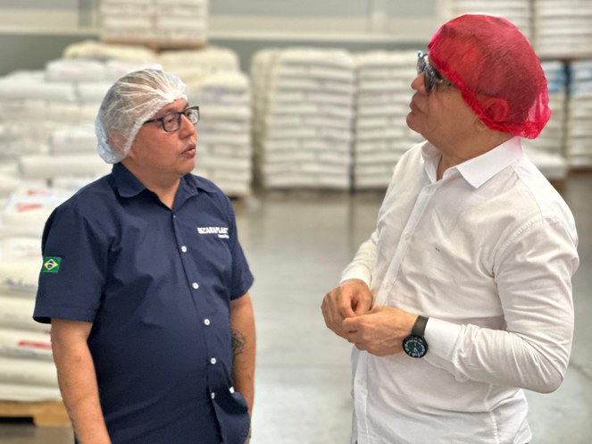 Foto mostra dois homens com touca na cabeça conversandoi