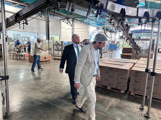 Foto mostra homens de touca andando em meio a máquinas numa fábrica