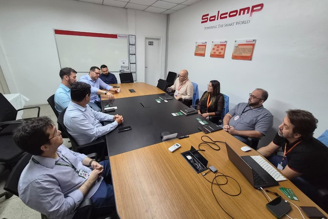 Foto mostra pessoas numa sala reunidas