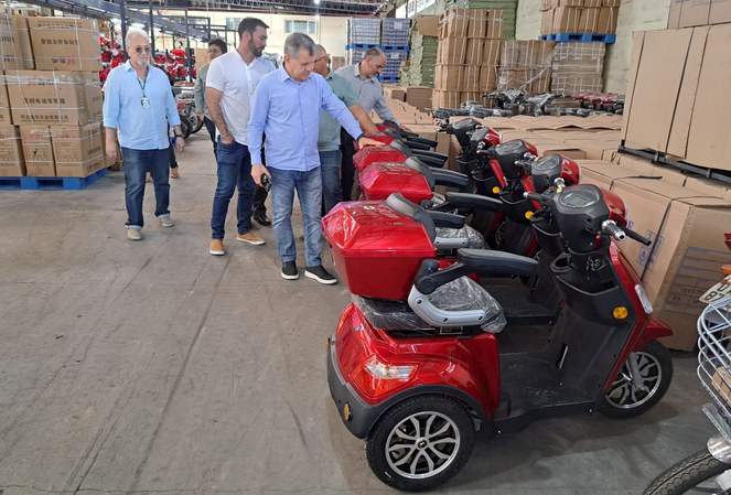 Foto mostra homem de blusa azul tocando em motocicleta