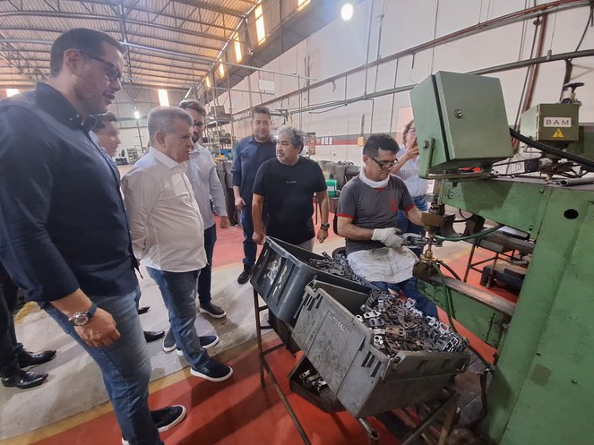 Foto mostra homem manuseando umas peças numa máquina