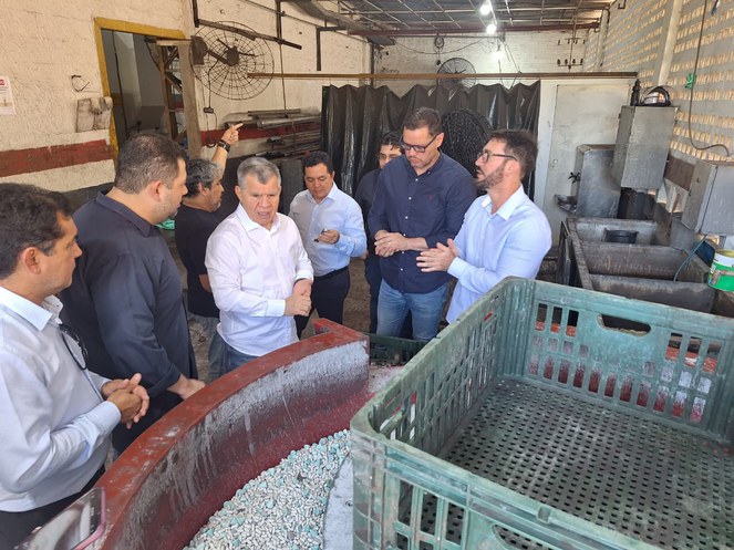 Fotos mostra grupo de pessoas numa fábrica