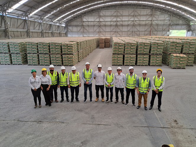 Foto mostra um grupo de pessoas vestidas com EPIs em visita a uma fábrica de cimento