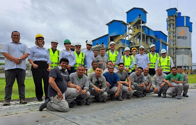 Foto mostra grupo de pessoas vestidas com EPIs e outras não, em visita a uma fábrica de cimento