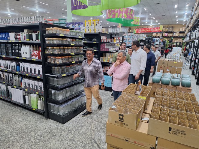 Foto mostra homens andando dentro de um estabelecimento comercial