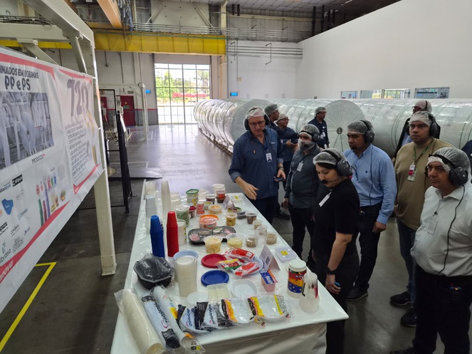 Foto mostra pessoas conferindo estande de produtos plásticos