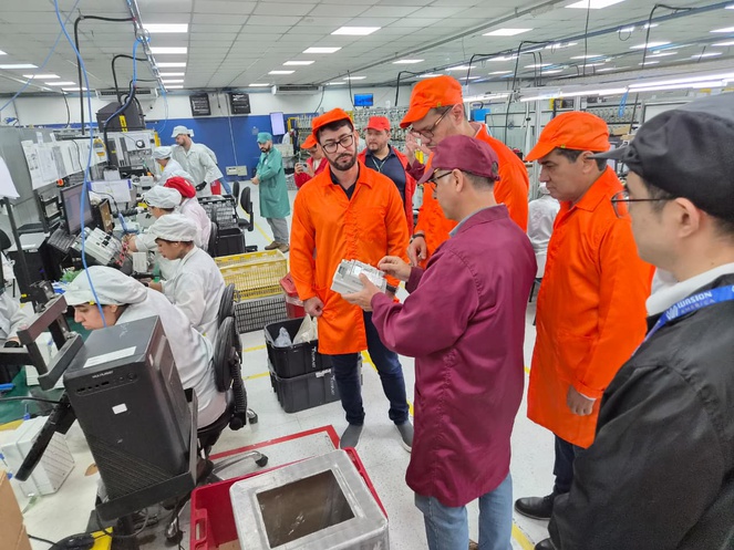 Foto mosta homem manuseando medidor de energia elétrica inteligente, observado por outras pessoas